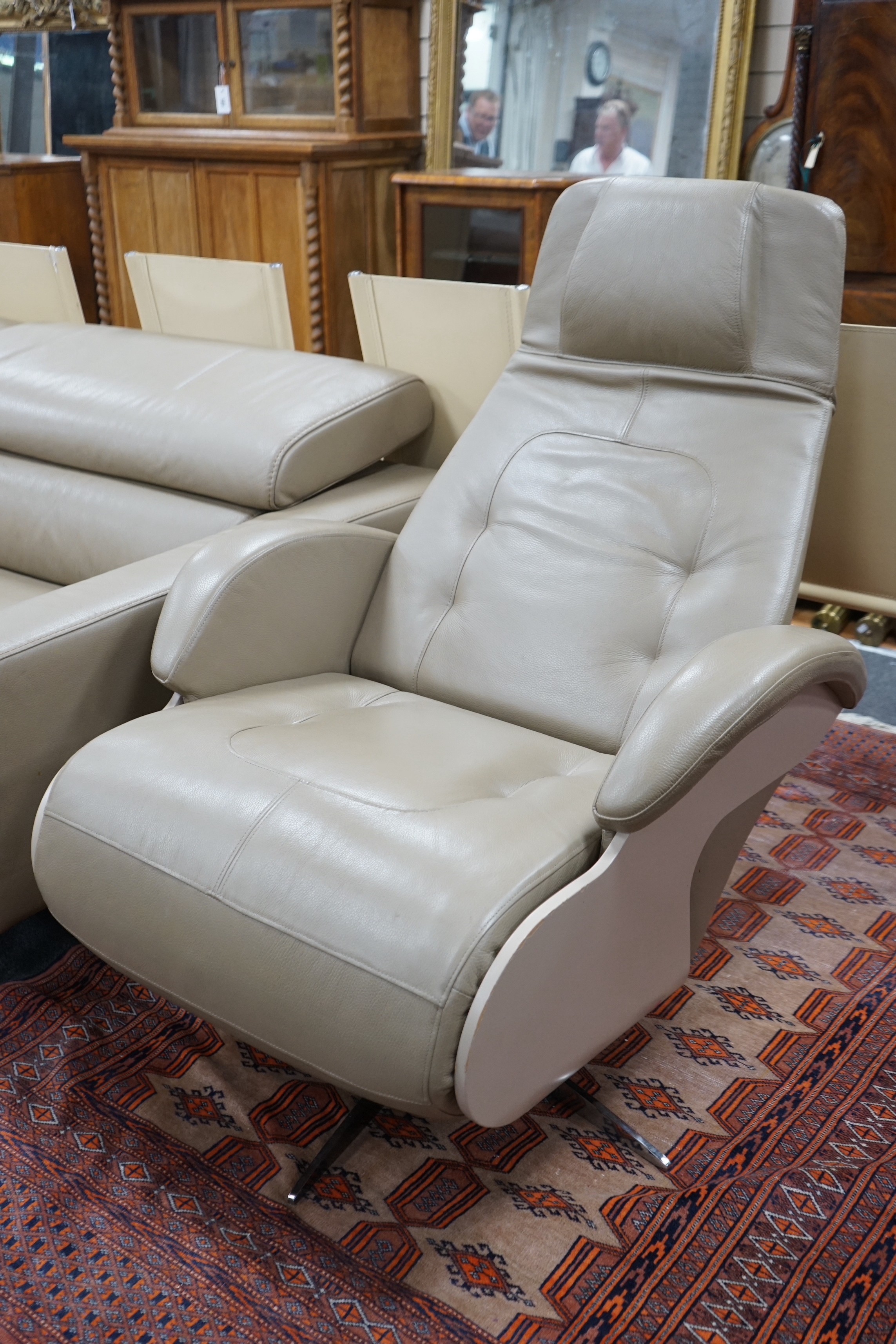 Roche Bobois, a pair of contemporary “First Class” electric reclining swivel armchairs in Sidney leather, colour 87 Mastic, on five prong chrome bases with lacquer sides, width 79cm, depth 90cm, height 110cm